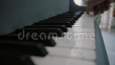 一个人手指着钢琴的琴键. 演奏钢琴的男乐手。 弹钢琴的钢琴家的手指
